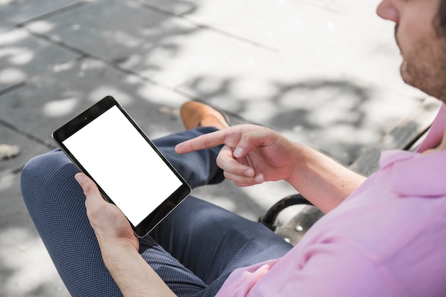 Crop man pointing at tablet