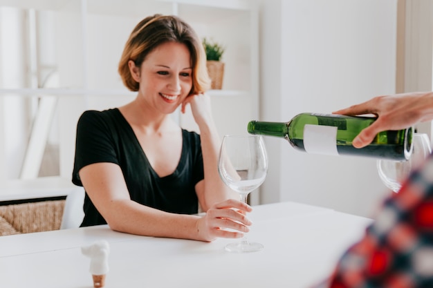 Crop man pouring wine for woman