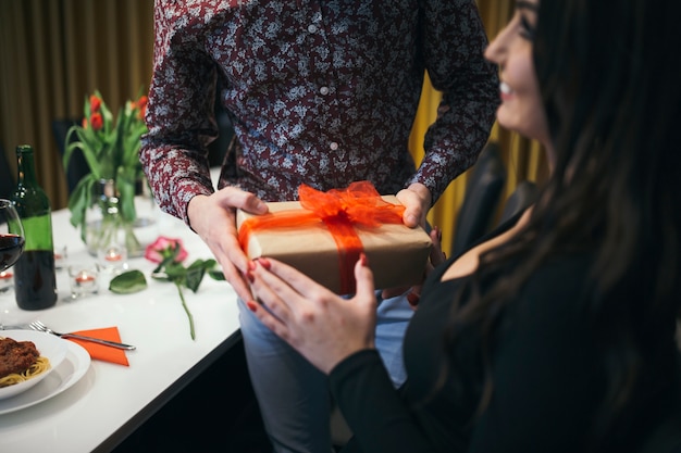 Free photo crop man presenting giftbox to woman