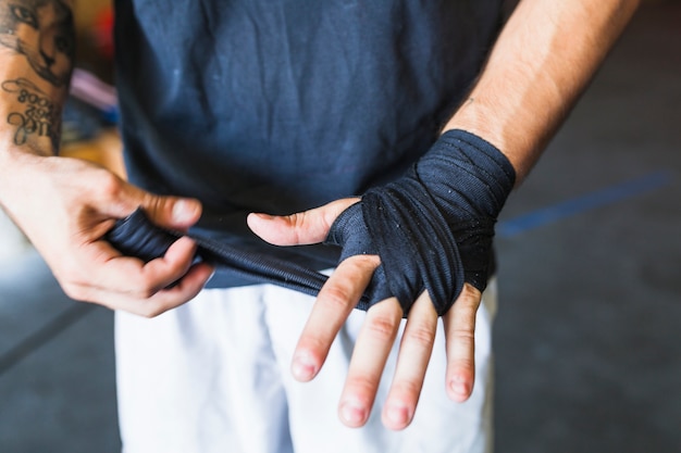 Crop man protecting hand with band