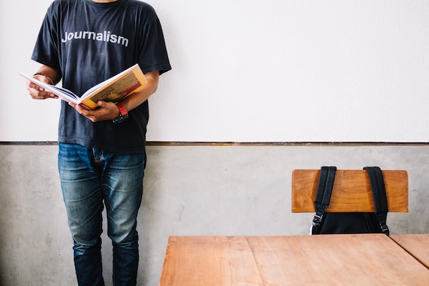 Free photo crop man reading book near whiteboard