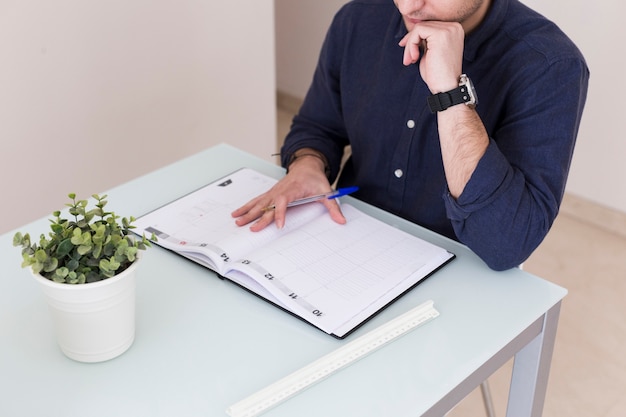 Free photo crop man reading notes in notebook