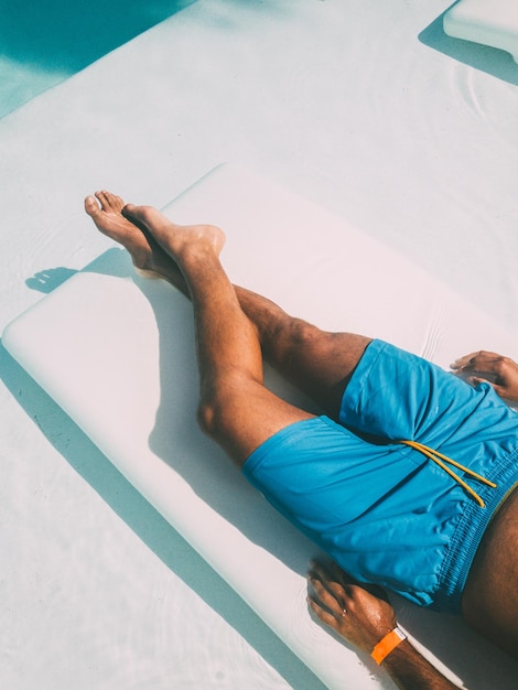 Foto gratuita crop uomo in appoggio sul lettino a bordo piscina