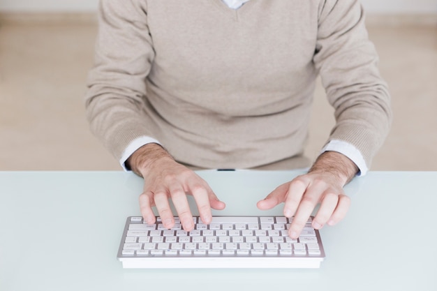 Crop man using computer keyboard