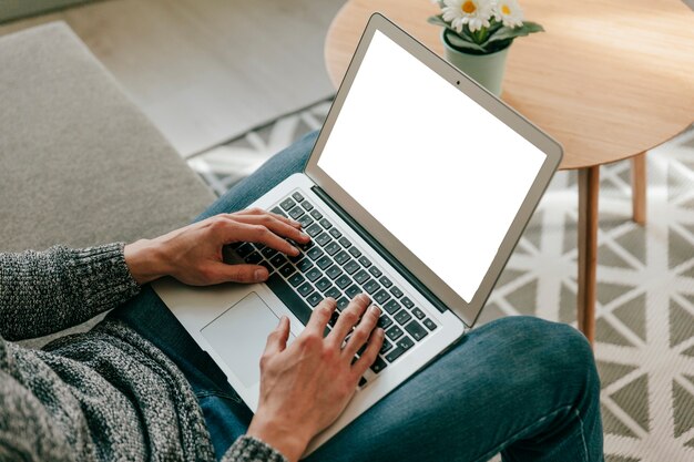 Crop man using laptop in living room