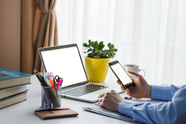 Crop man using smartphone in office