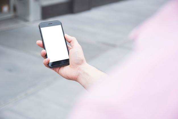 Crop man using smartphone on street