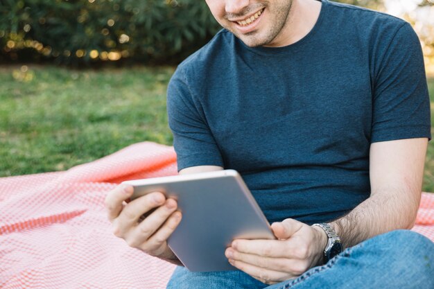 ピクニックでタブレットを使用して作物の男