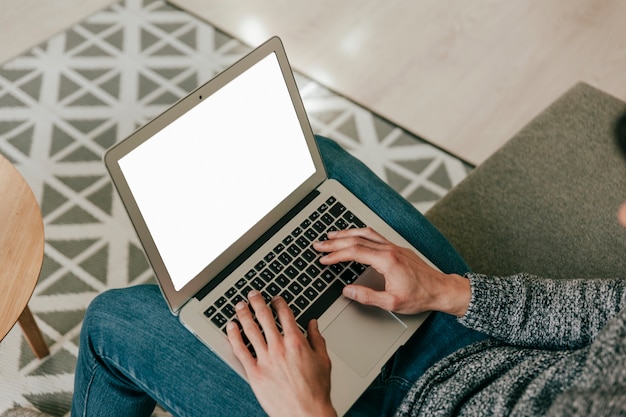 Crop man with laptop on sofa