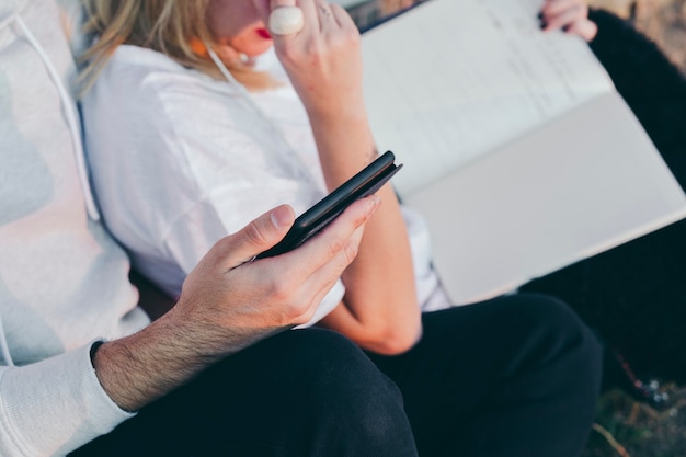 Crop man with tablet chilling with girlfriend