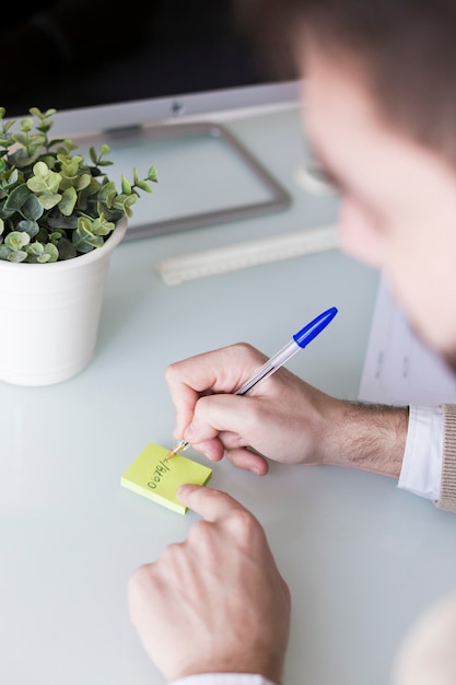 Crop man writing down information