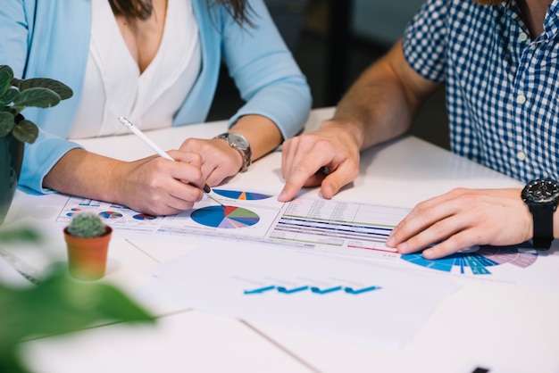 Crop people comparing data in chart