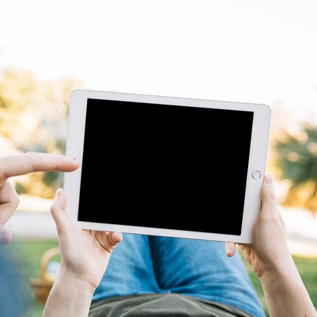 Crop people pointing at tablet