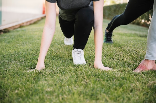 Free photo crop people preparing to run on grass