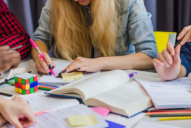 Crop people studying with textbooks