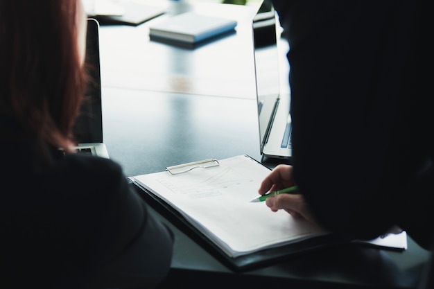 Crop people watching document on clipboard