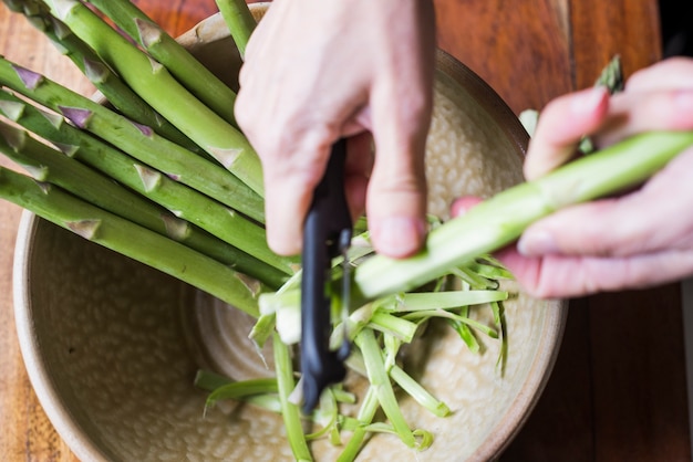 Free photo crop person cleaning asparagus