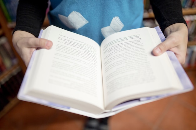 Crop person enjoying book in bookstore