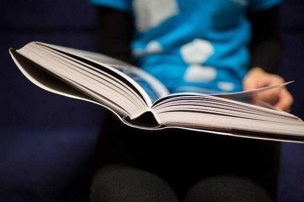 Crop person enjoying book