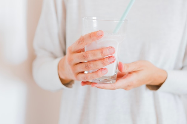 Foto gratuita raccolga la persona che tiene il bicchiere di latte