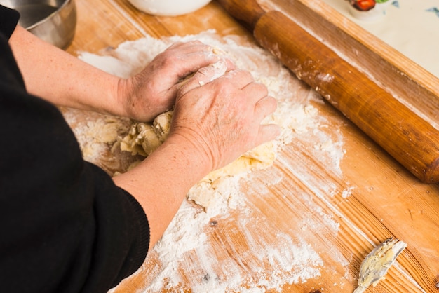 Crop person kneading dough