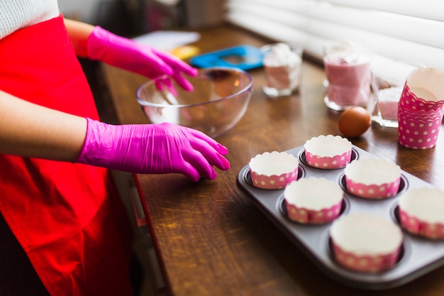 Crop person preparing to cook muffins