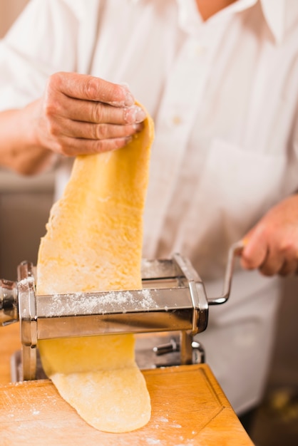 Free photo crop person rolling dough for pasta