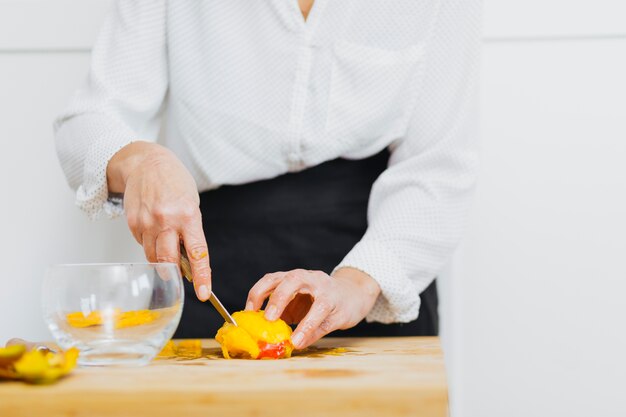 Crop person slicing fruit