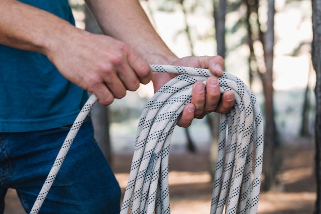 Crop person wrapping rope