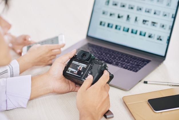 Foto gratuita ritaglia i fotografi con laptop e macchina fotografica