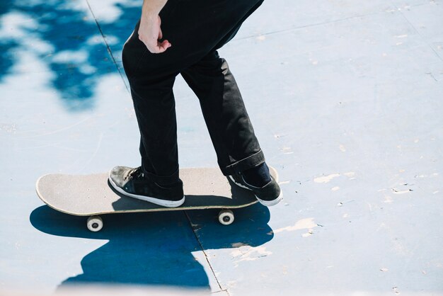 Crop skateboarder riding on ramp