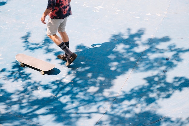 Free photo crop skateboarder walking in park