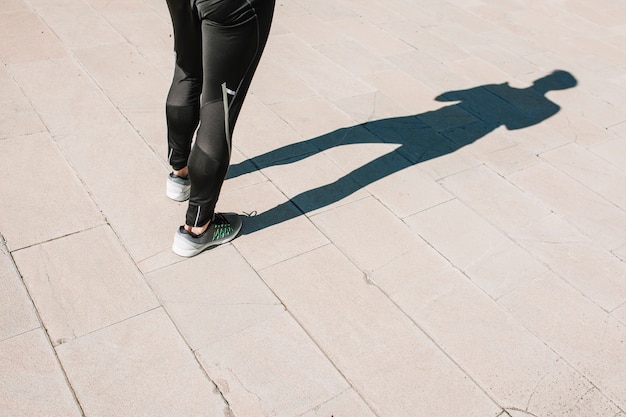 Crop sportsman standing on pavement