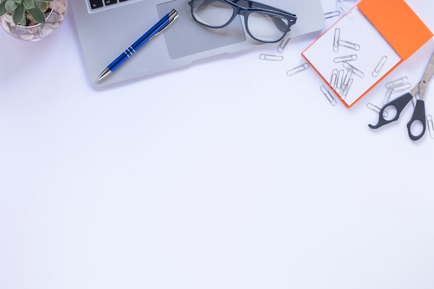 Crop stationery and laptop on white