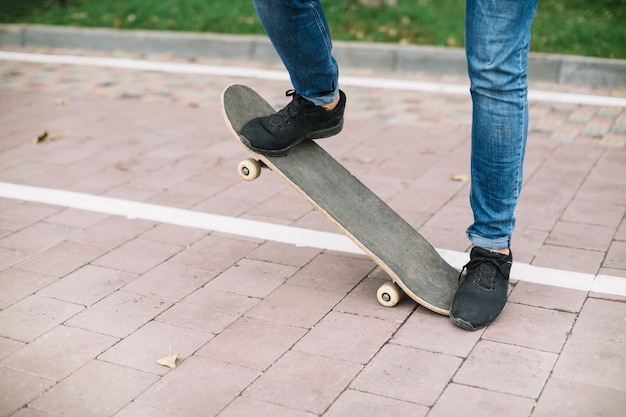 Ritaglia adolescente facendo acrobazia su skateboard