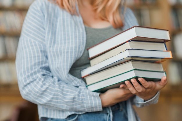 Free photo crop teenager with heap of books