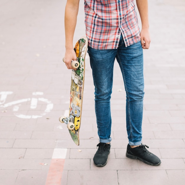 Raccolga l'adolescente con lo skateboard vicino alla pista ciclabile