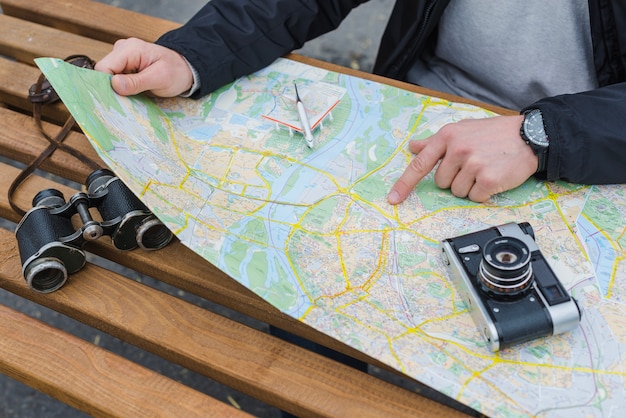 Crop tourist pointing at map