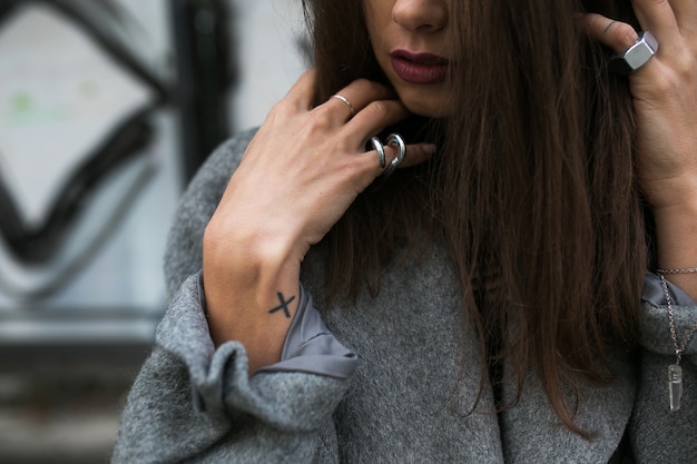 Crop woman in accessories posing in coat