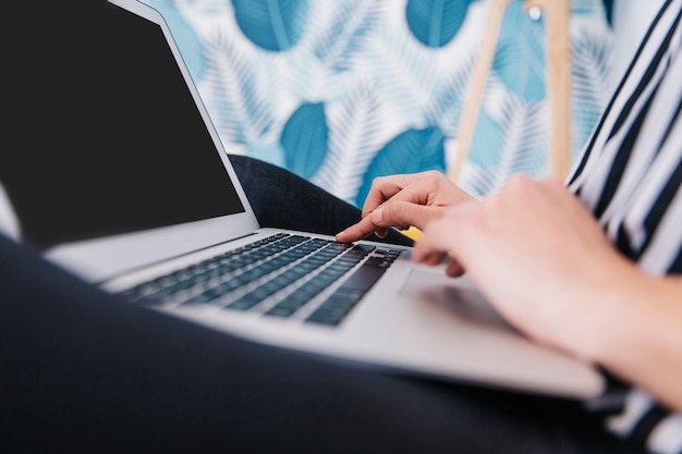 Crop woman browsing laptop