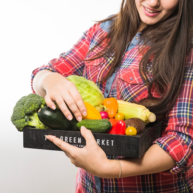 Crop woman choosing vegetables from pallet