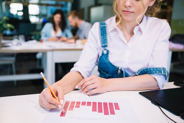 Crop woman correcting charts