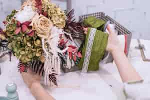 Free photo crop woman decorating bouquet