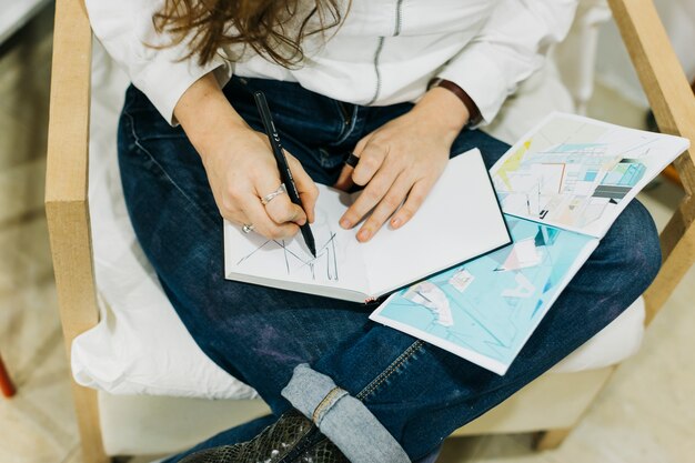 Crop woman drawing on lap