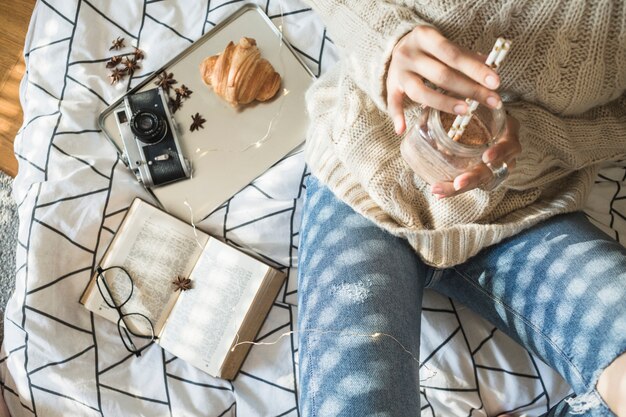 カメラと本の近くで女性を飲む作物