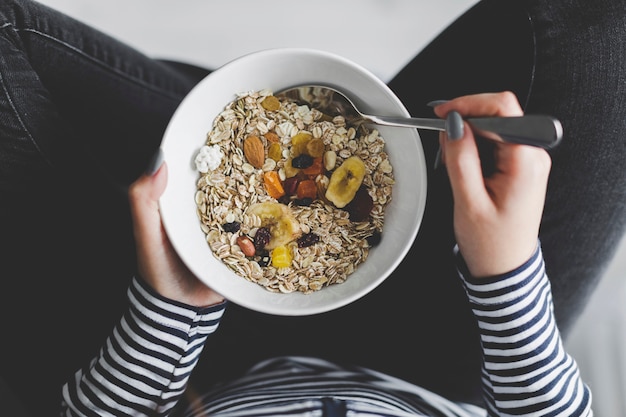 Crop woman eating muesli