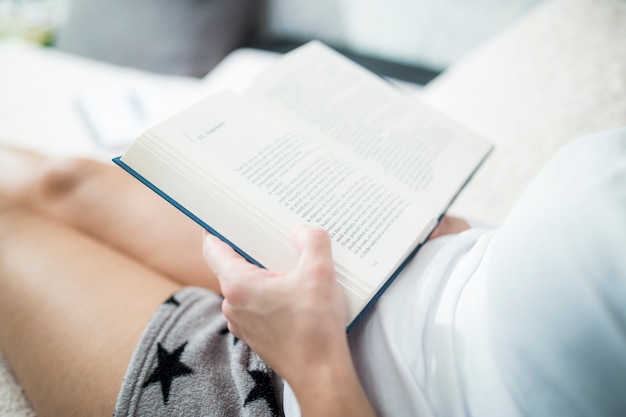 Crop woman enjoying reading