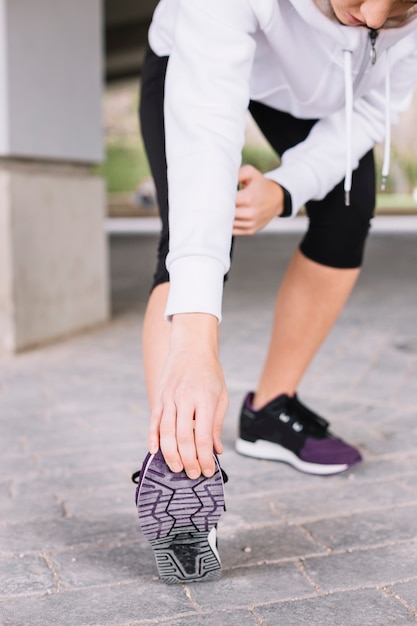 Crop woman exercising on pavement