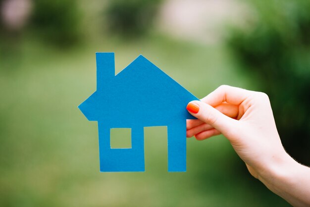 Crop woman holding blue house