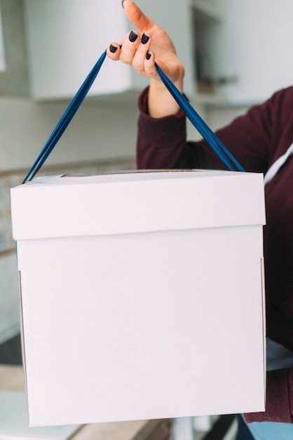 Crop woman holding cake box